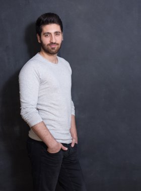 Kara tahta poz genç ve yakışıklı bir adam stüdyo resmi