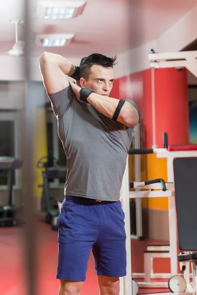 Muscular hombre levantando mancuerna en el gimnasio — Foto de Stock