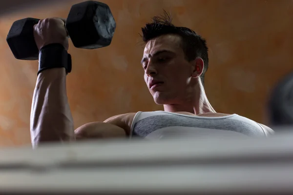 Hombre fuerte en el gimnasio levantando pesas pesadas — Foto de Stock