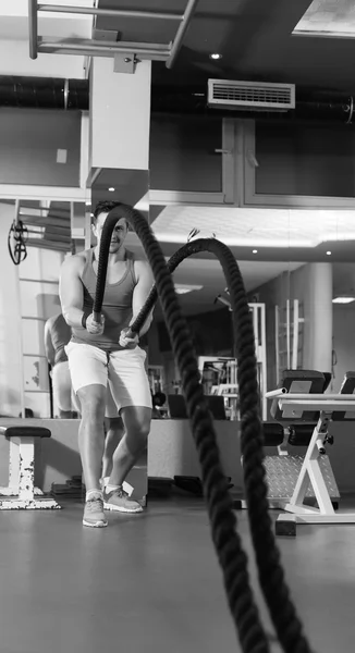 Hombre de las cuerdas de batalla en el ejercicio de gimnasio cuerpo ajustado ejercicio — Foto de Stock