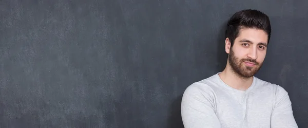 Handsome Young Man Smiling at the Camera Against chalkboard Wall — Stock Photo, Image