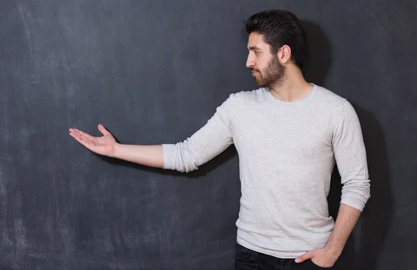 Bell'uomo con la barba che mostra qualcosa sulla lavagna, copiare sp — Foto Stock