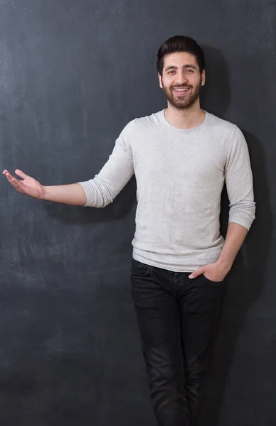 Handsome man with beard showing something on chalkboard, copy sp — Stock Photo, Image