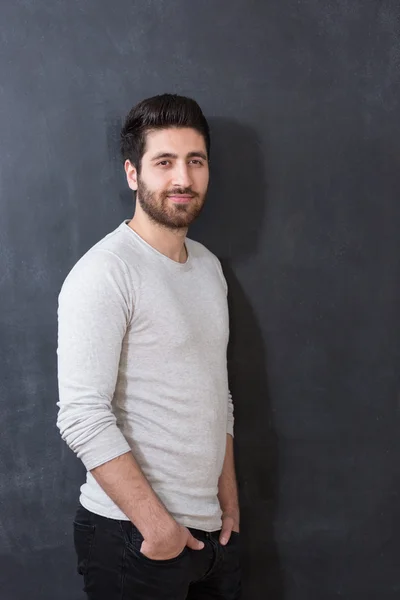 Atelierbild eines jungen, gut aussehenden Mannes, der auf einer Tafel posiert — Stockfoto