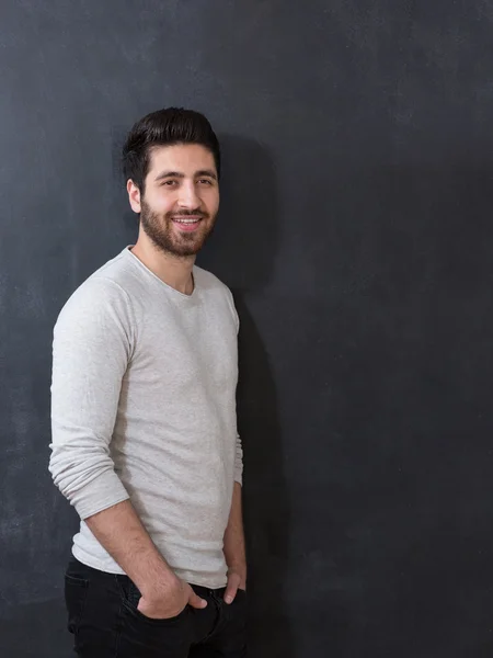 Studio picture of a young and handsome man posing on chalkboard — Stock Photo, Image