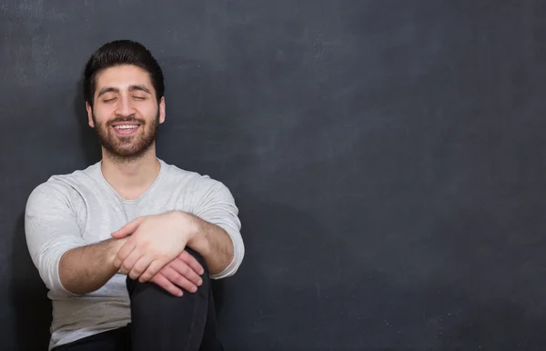 Happy young man looking up to blank  dark chalkboard — Stock Photo, Image