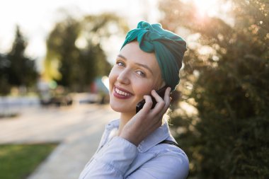 Trendy bir görünüm akıllı telefon ızg üzerinde sohbet ile genç hippi kız