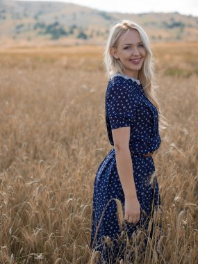 Çekici sarışın yürüyüş ve yaz da çavdar alan poz