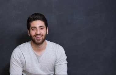 siyah arka planda büyük bir gülümseme ile yakışıklı delikanlı