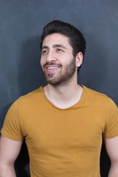 Attractive young man against blackboard. — Stock Photo, Image