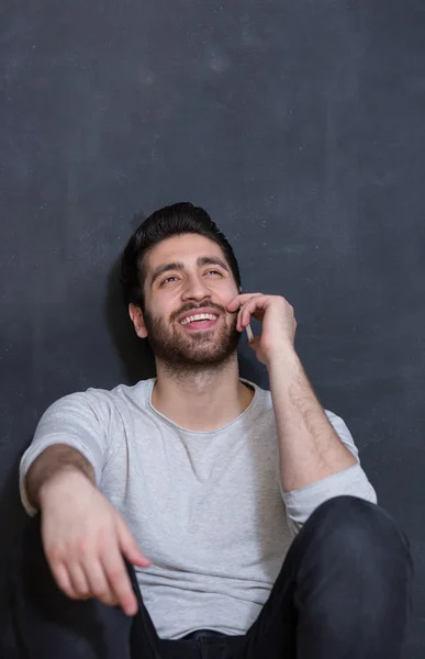 Casually handsome. Handsome young arabic man holding cell phone — Stock Photo, Image