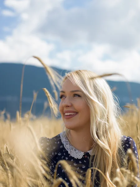 Junge schöne Frau auf goldenem Getreidefeld im Sommer — Stockfoto