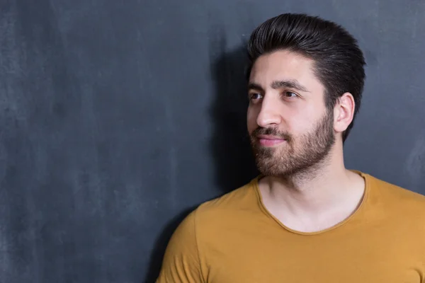 Attractive young man against blackboard. — Stock Photo, Image