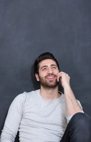 Casually handsome. Handsome young arabic man holding cell phone — Stock Photo, Image