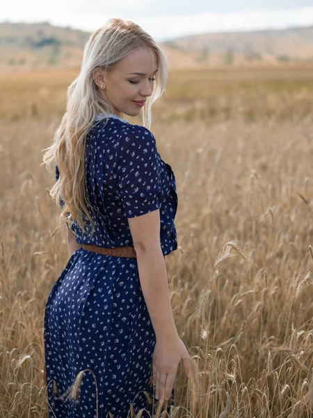 Attractive blonde walking and posing on a rye field in summer da — Stock Photo, Image