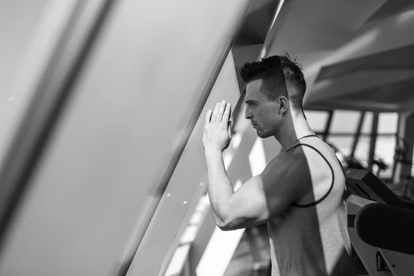 Pensive sportsman looking through the window — Stock Photo, Image