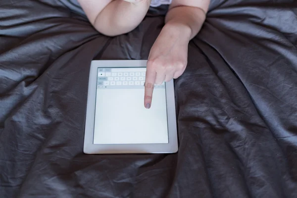 Mujer usando tableta en su cama — Foto de Stock