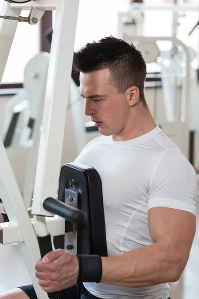 Homme faisant des extraits sur la machine dans la salle de gym — Photo