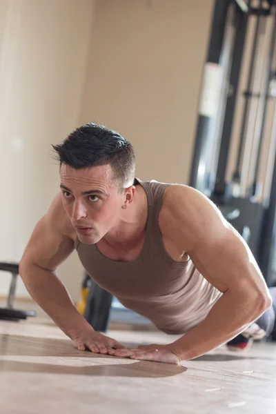 Hombre guapo en forma haciendo ejercicio en el gimnasio — Foto de Stock