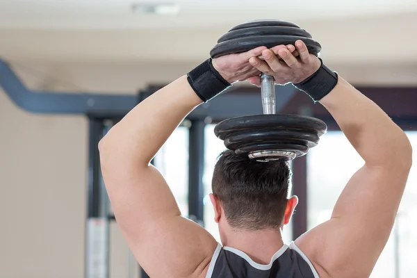 Athlete muscular bodybuilder man demonstrates his muscles in the — Stock Photo, Image