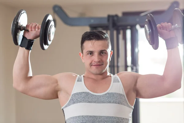 Atleta musculoso culturista hombre demuestra sus músculos en el —  Fotos de Stock