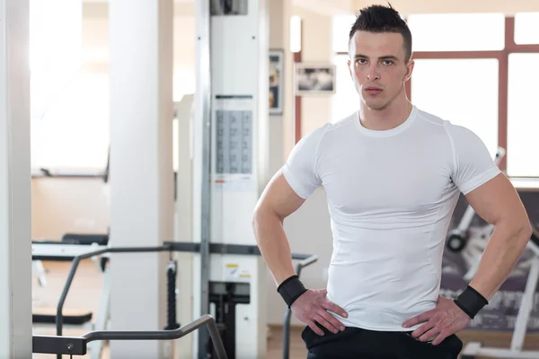 Homem desportivo a descansar num ginásio. Retrato de um jovem desportivo muscular — Fotografia de Stock