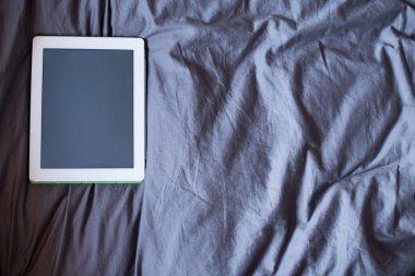 Beyaz yatakta tablet