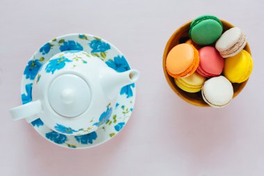 Pastel arka plan üzerinde çay ile renkli macaroons