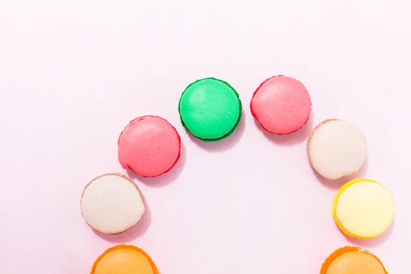 Galletas macarrones franceses de colores dulces sobre fondo pastel, a — Foto de Stock