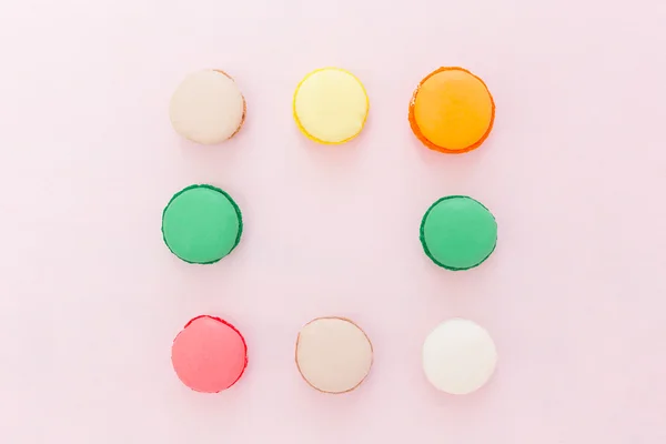 Galletas macarrones franceses de colores dulces sobre fondo pastel, a — Foto de Stock