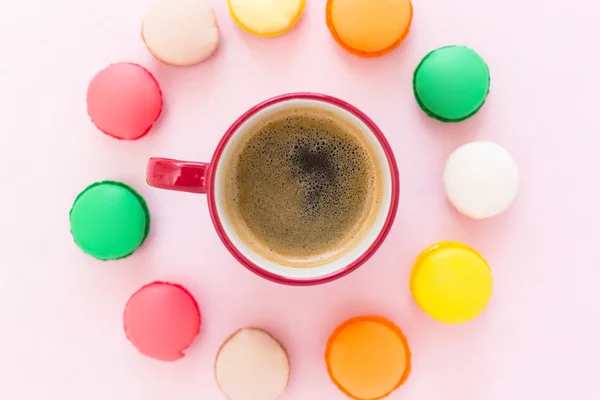 Copo de café e macaroons coloridos no fundo pastel, vista superior — Fotografia de Stock
