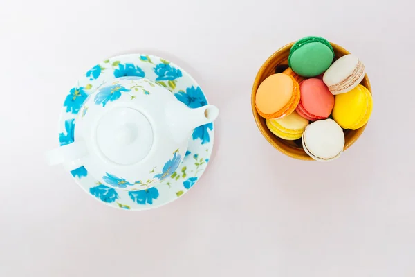 Färgglada macaroons med kopp te på pastell bakgrund — Stockfoto
