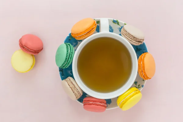 Macarons colorés avec tasse de thé sur fond pastel — Photo