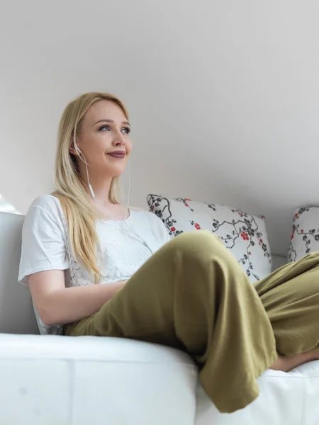 Casual mujer joven pensativa sentada en el sofá en casa — Foto de Stock