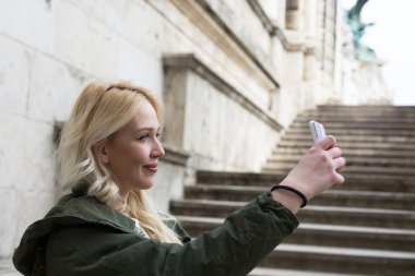 Kız kendini akıllı telefon alarak fotoğraf ile. Budapeşte