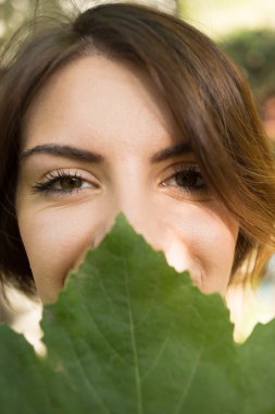 Güzel kadının yüz tarafından yeşil yaprak, bea kavramı kaplı