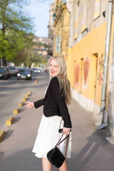 Joven mujer de negocios bonita en gafas de sol sonriendo y caminando nea — Foto de Stock