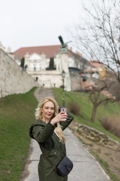 Красивая молодая блондинка-туристка фотографирует . — стоковое фото