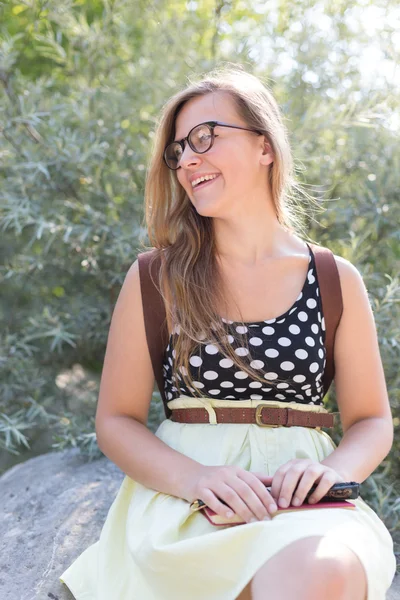 Una bella giovane donna sorridente con i capelli lunghi e biondi è seduta o — Foto Stock