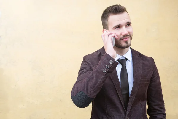 Unga trendiga män i kostym mot gul vägg — Stockfoto