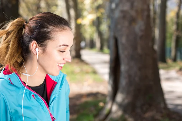 Succesvolle atlete doen positieve en dragen oortelefoons — Stockfoto