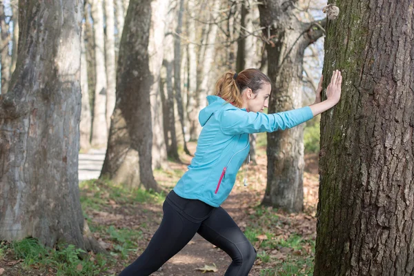 Mujer sana de fitness descansando en el bosque después de una carrera de senderos. vitali —  Fotos de Stock