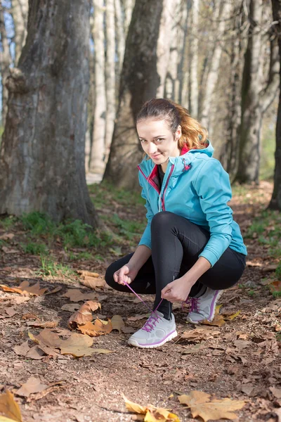 Mujer sana de fitness descansando en el bosque después de una carrera de senderos. vitali —  Fotos de Stock