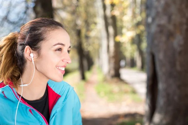Successful female athlete doing positive  and wearing earphones