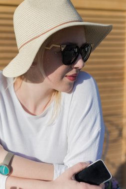 Kız şapka ve güneş gözlüğü smartphone holding