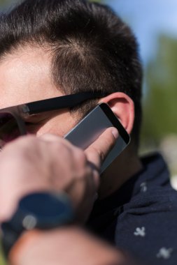 Akıllı telefondan konuşan genç adam. 