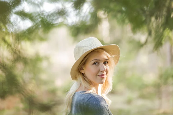 Vrouw in stro hoed in het bos — Stockfoto