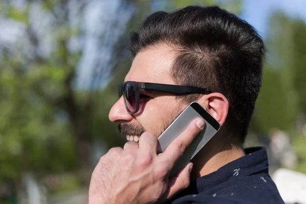 Joven barbudo hombre hablando en smartphone — Foto de Stock