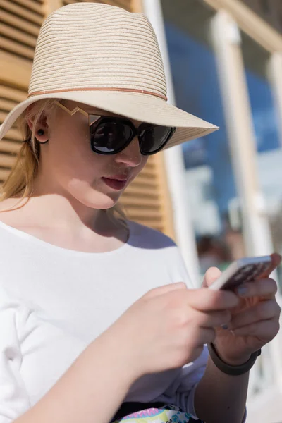 Ontspannende vrouw met smartphone buitenshuis — Stockfoto