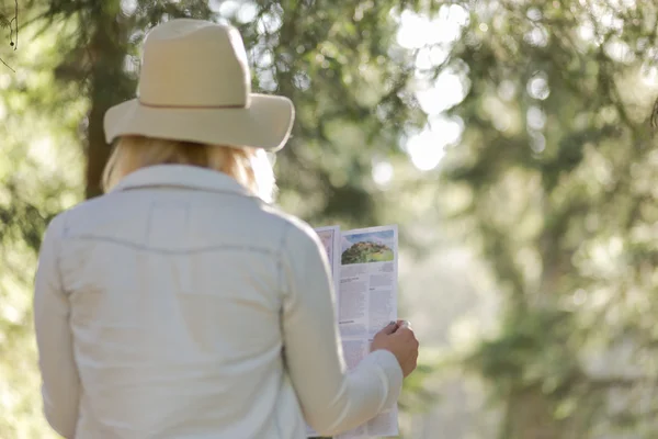 Female explorer looking at a map outdoor — Stock Photo, Image